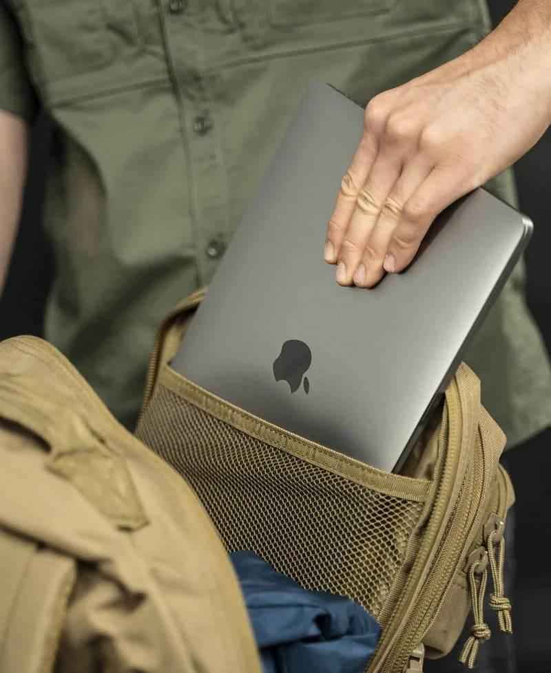 Mochila táctica beige con funda interior de malla y laptop guardada.