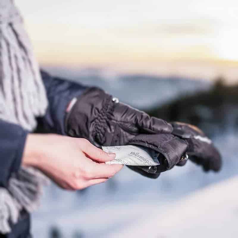 Almohadilla térmica Thermopad en envoltorio negro, sostenida con la mano
