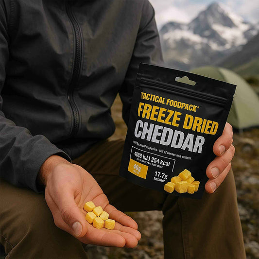 Snack liofilizado de queso cheddar: bolsa Tactical Foodpack y cubos en la mano.